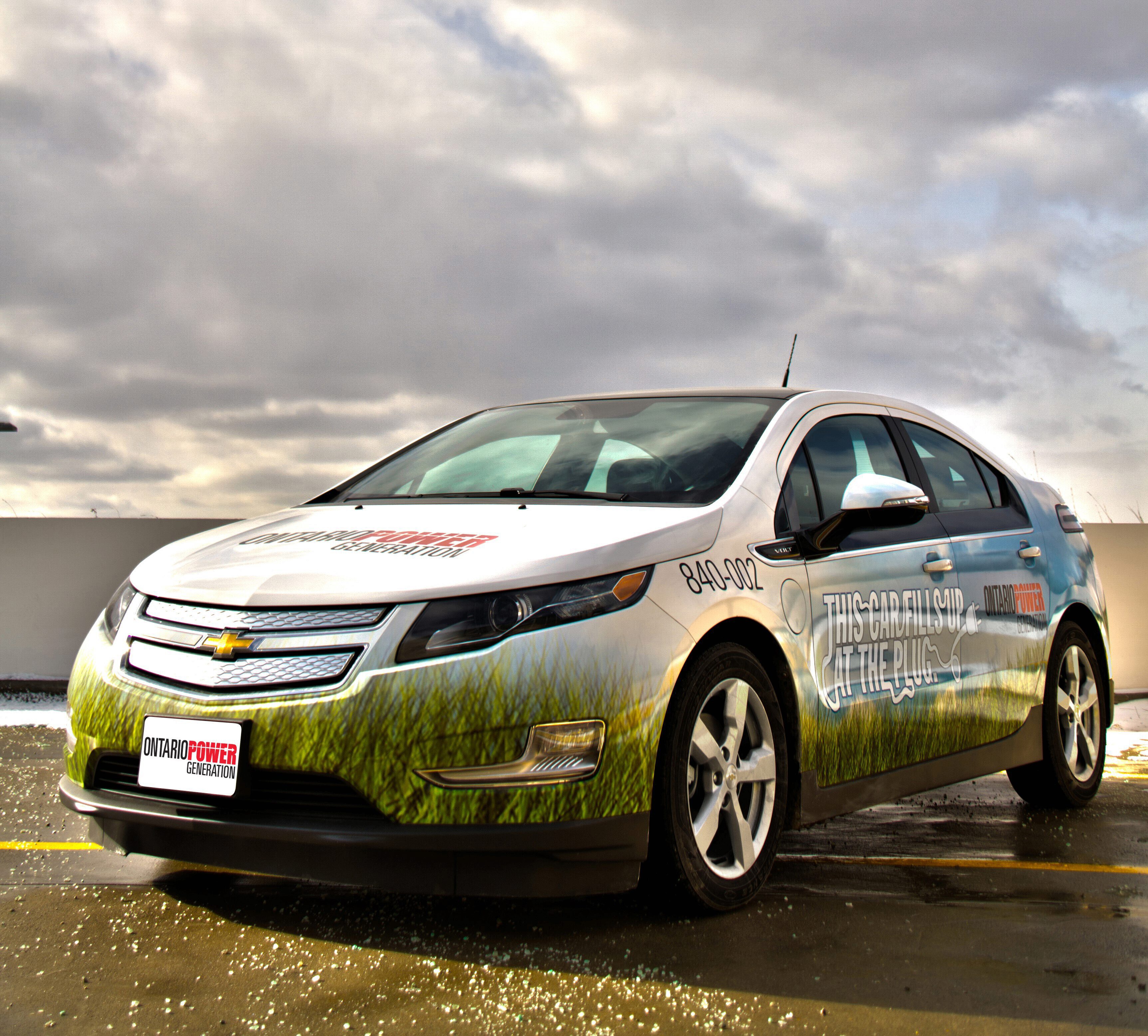 OPG fleet vehicle covered in "This Car Fills Up at the Plug" decal.