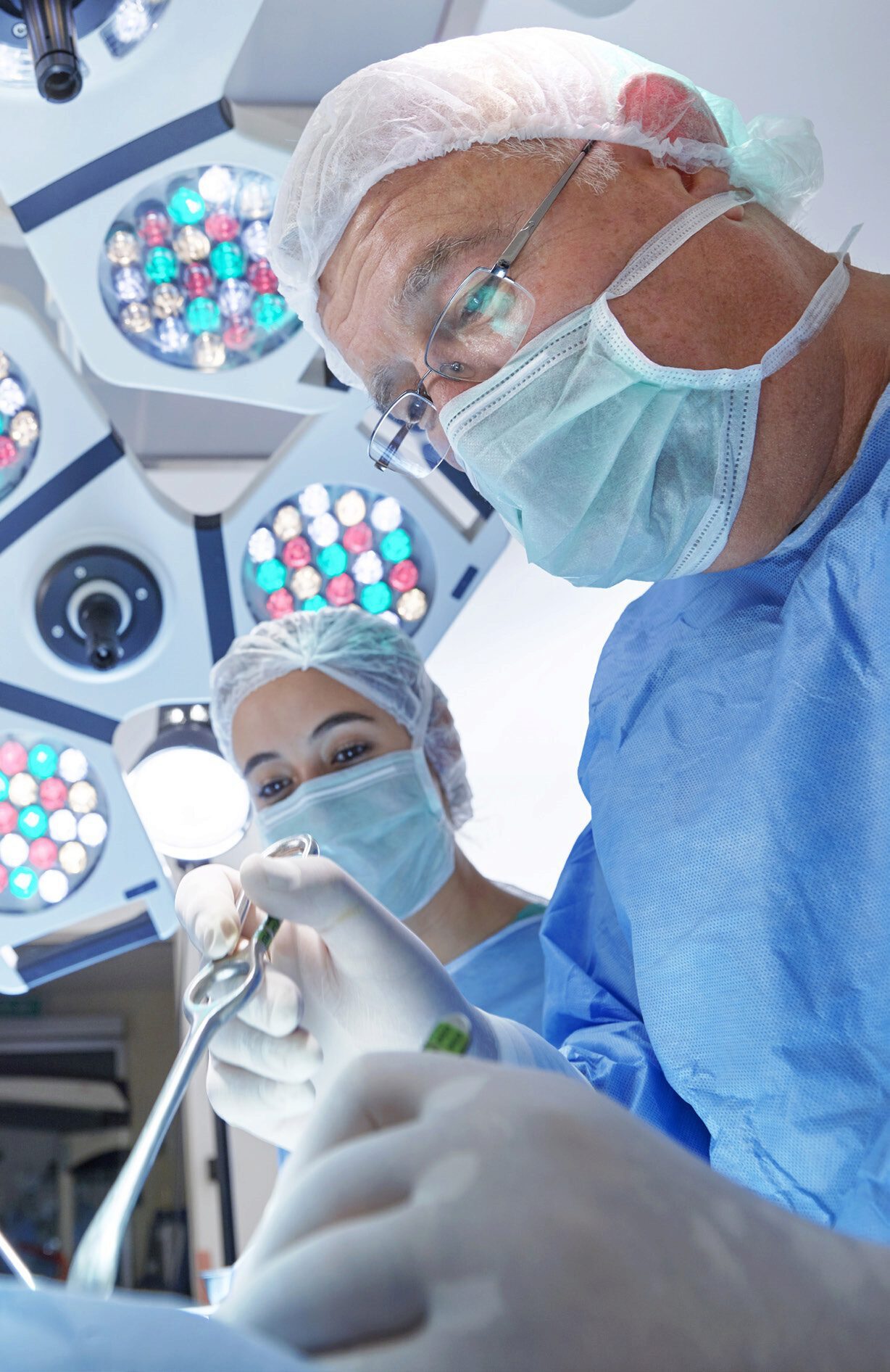 Medical staff holding surgical equipment in an operating room.