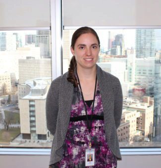 OPG employee Kim Loader stands in front of an office window.