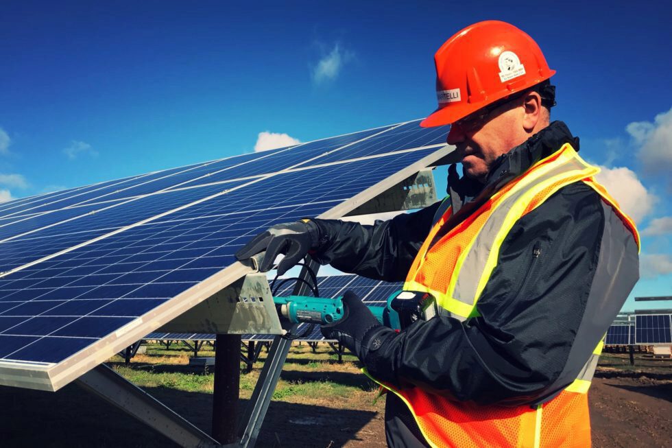 Man working on a solar panel at the Nanticoke Solar facility.