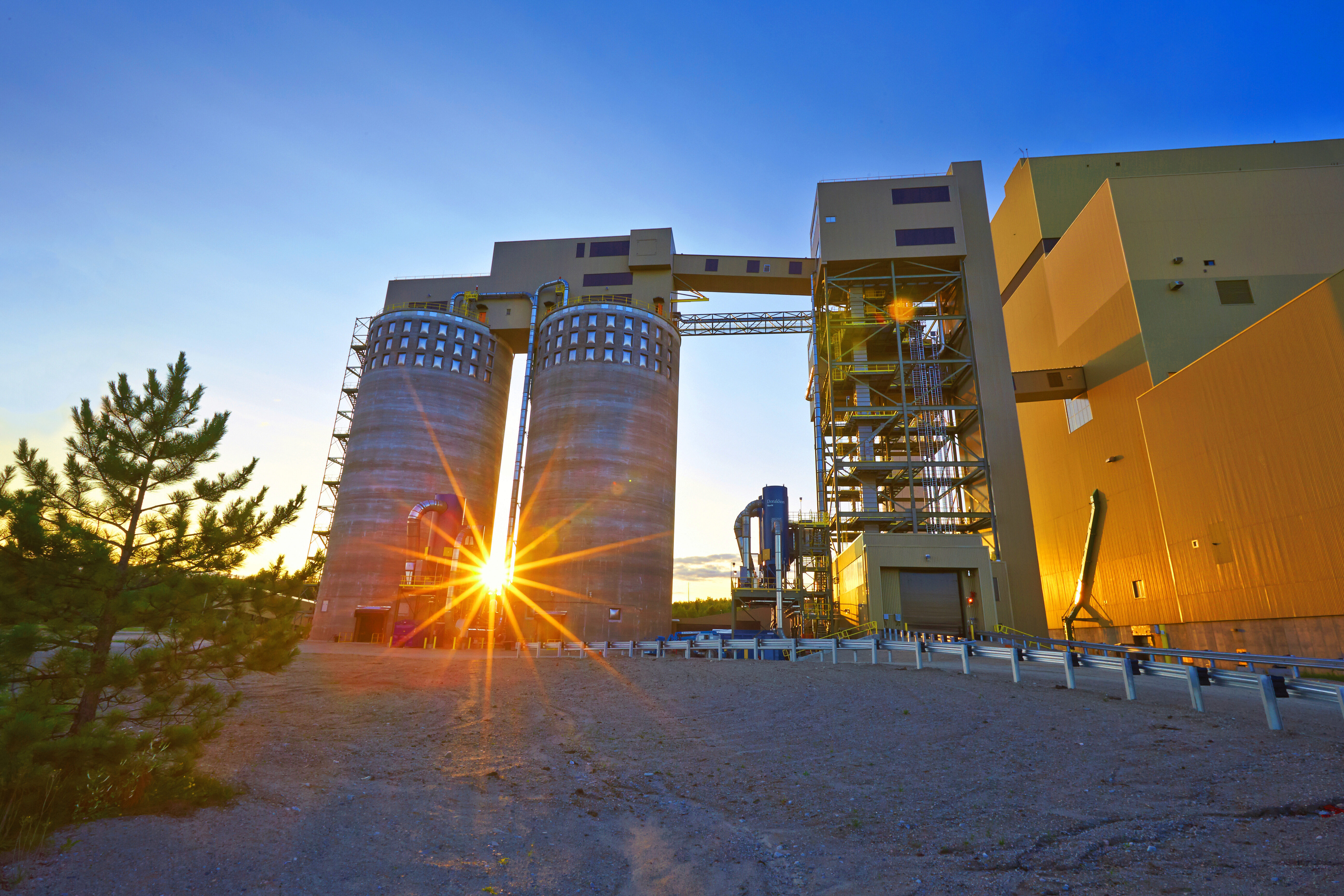 Sunset peeking between the biomass pellet storage silos at Atikokan Generating Station.