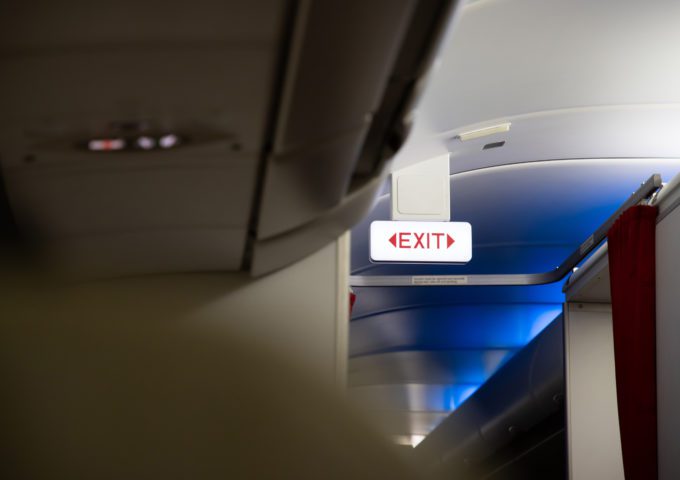 Emergency exit sign hanging on airplane night flight.