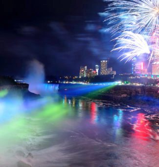 Fireworks explode in the air at night above horseshoe falls in Niagara Falls.