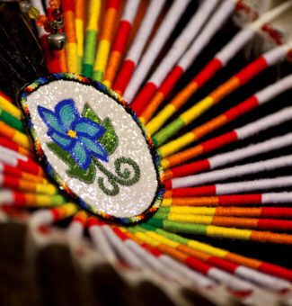A close-up of a colourful bustle, part of an Indigenous man’s traditional regalia typically worn at a pow wow.