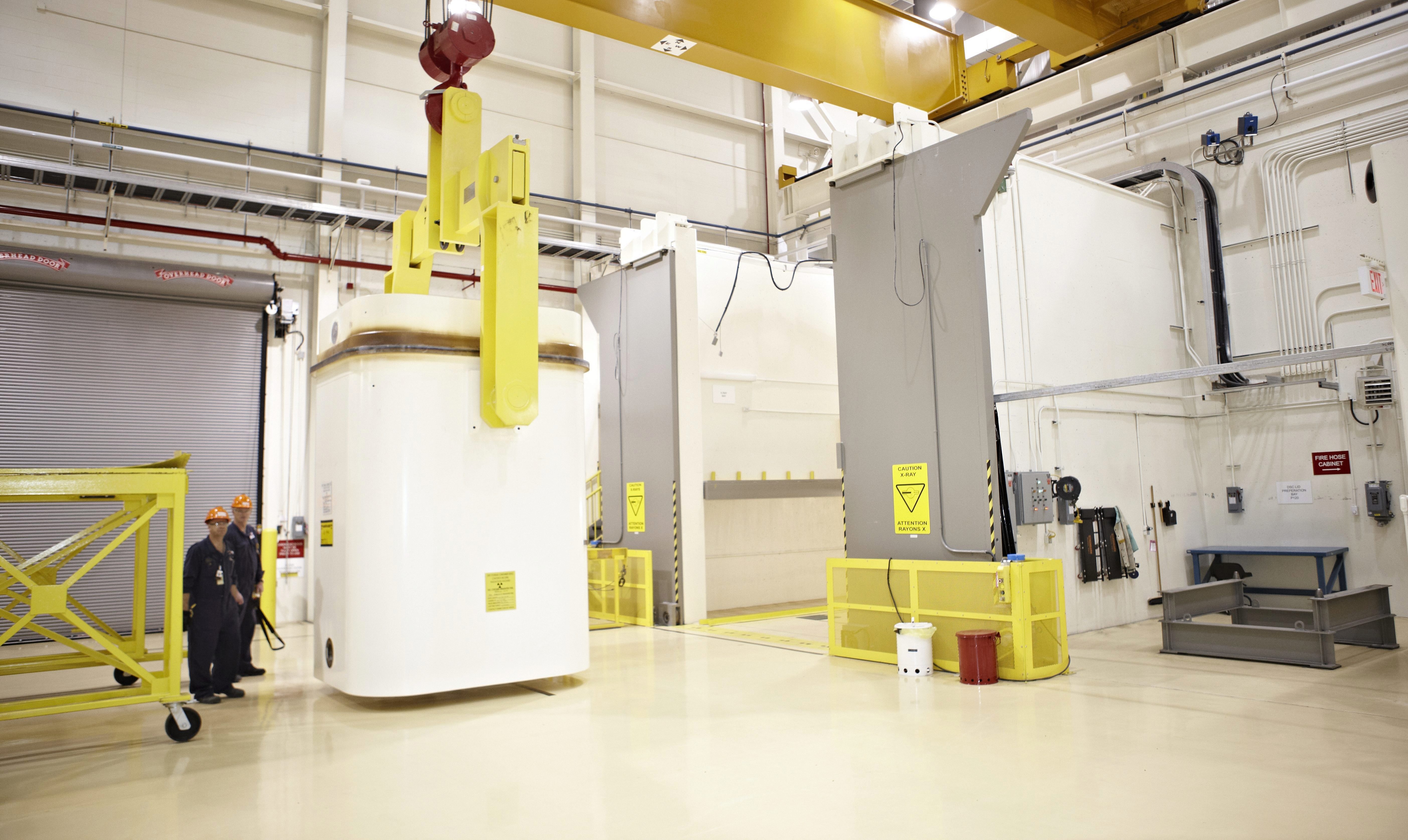 A dry waste storage contained attached to a hoist at a nuclear waste storage facility.