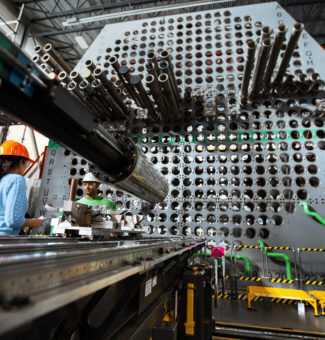 Workers in hard hats train for their work on a full-scale nuclear reactor mock-up.