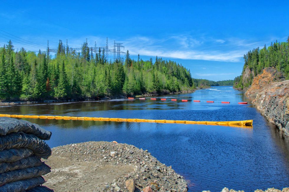 Water safety booms stretched cross a river.