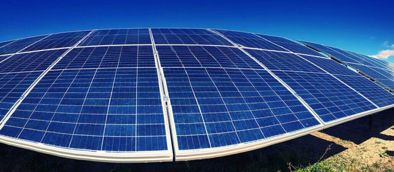 Workers near a large solar panel installation.