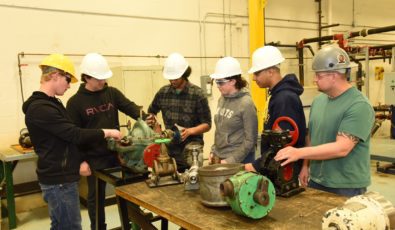 Students in the new three-week boilermaker pre-apprentice program pose for a photo in the training area at Durham College's Whitby Campus.