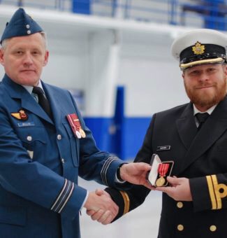 Major Paul Willis (left) presents OPG engineer, Lieutenant John Hunter (right) with the Canadian Forces Decoration medal for 12 years of military service.