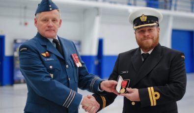 Major Paul Willis (left) presents OPG engineer, Lieutenant John Hunter (right) with the Canadian Forces Decoration medal for 12 years of military service.