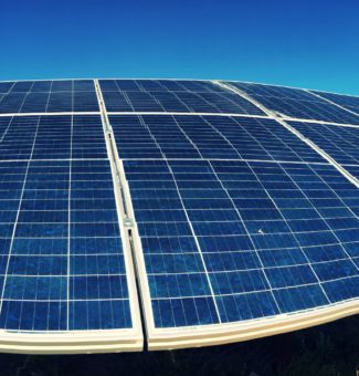 Workers near a large solar panel installation.