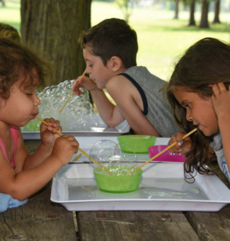Kids take part in a science experiment using bubbles.