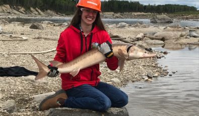 Melodie Tessier, OPG Site Environmental Advisor, holds a lake sturgeon.