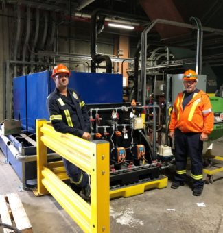 Environmental, Chemistry and Safety Technicians John Visser and Grant Rogoza stand in front of the dosing equipment that injects the citric acid into Atikokan’s furnace ash water​.