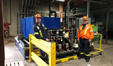 Environmental, Chemistry and Safety Technicians John Visser and Grant Rogoza stand in front of the dosing equipment that injects the citric acid into Atikokan’s furnace ash water.