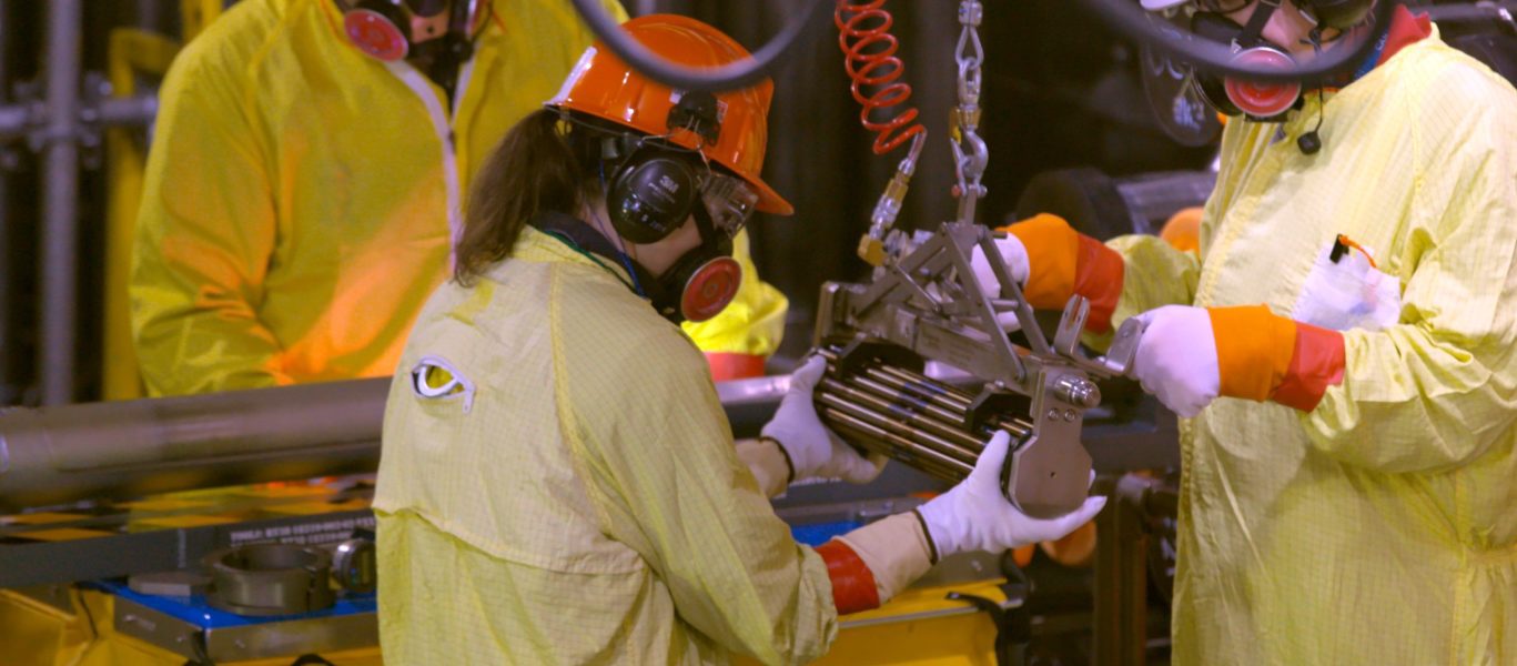 Workers load fuel into a nuclear reactor