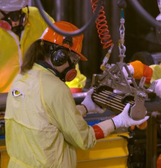 Workers load fuel into a nuclear reactor