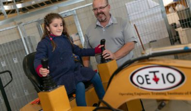 A young visitor tries her out a mini excavator at the OPG Open House at Darlington.