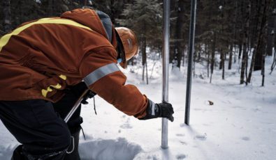 An employee performing a snow survey.