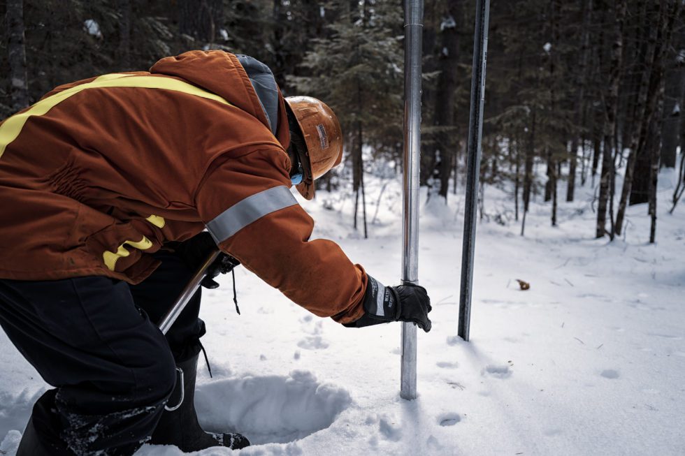 An employee performing a snow survey.