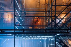 Welder working on boiler on scaffolding.