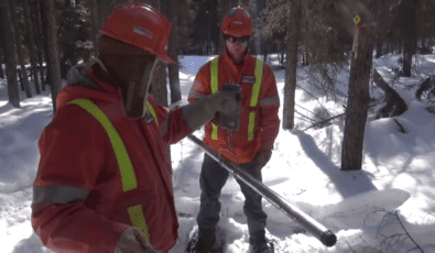 OPG's Alain Ratthe and Ed Smart weigh a snow sample using a digital scale.