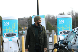 A man charging his electric vehicle at an Ivy Charging Network EV charging station.