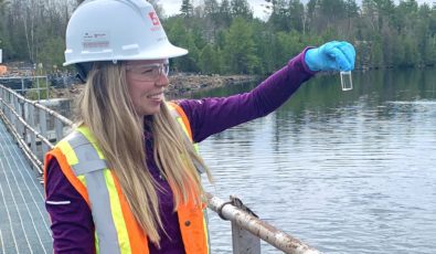 Carly Lance, a Junior Health, Safety and Environment Assistant with contractor M. Sullivan and Son, examines a water sample at OPG's Calabogie Redevelopment project site.