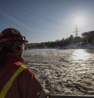 An water manager assesses water conditions near a hydroelectric dam.