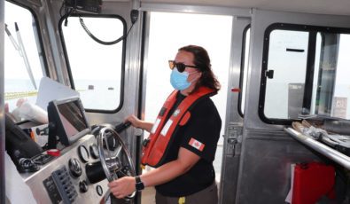 Dive Supervisor Jaimie Dack steers the boat.