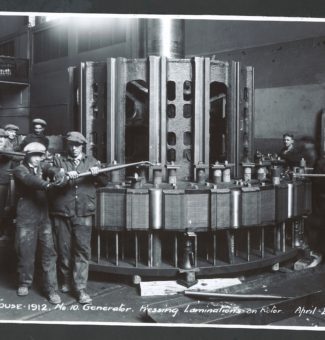 Workers press laminations on a rotor at Sir Adam Beck I GS.