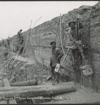 Workers drill along a wall of the forebay during construction of Sir Adam Beck I GS.