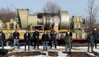Employees with OPG and E.S. Fox stand in front of a retired emergency power generator that will be used to train future millwrights.