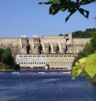 Safety booms in the water beside Stewartville Hydro Generating Station