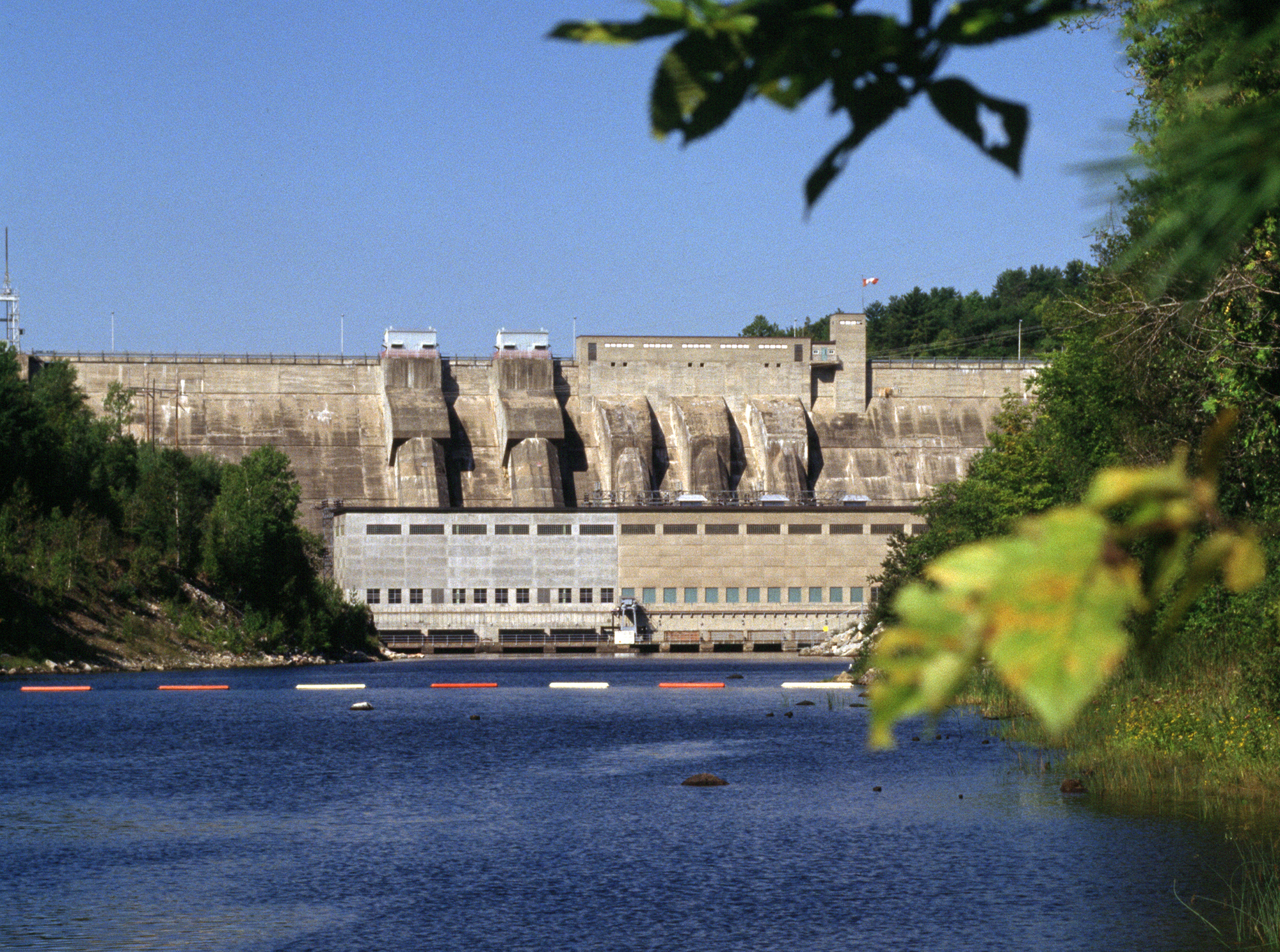 Safety booms in the water beside Stewartville Hydro Generating Station