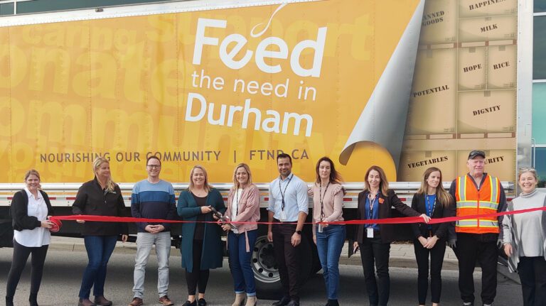 OPG employees cut a ribbon at a Feed the Need Durham event