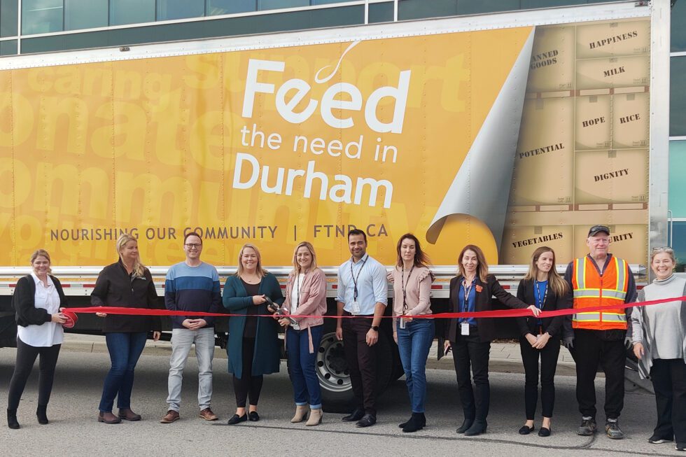 OPG employees cut a ribbon at a Feed the Need Durham event