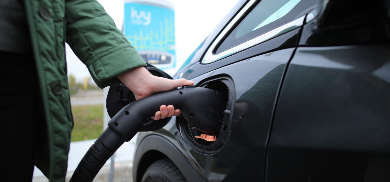 Plugging in an electric car at an Ivy Charging Network charging station.