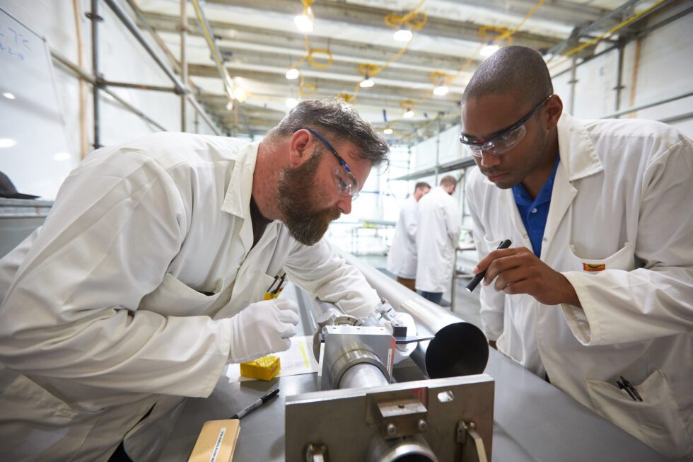 Workers inspecting calandria tubes