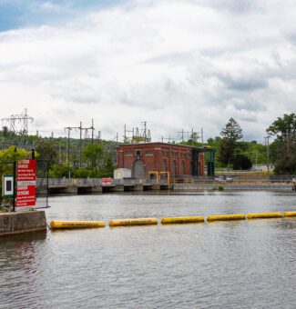 Safety boom in the water beside a hydroelectric generating station.