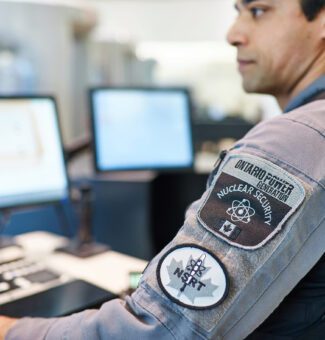 A nuclear security officer sitting at a computer workstation.