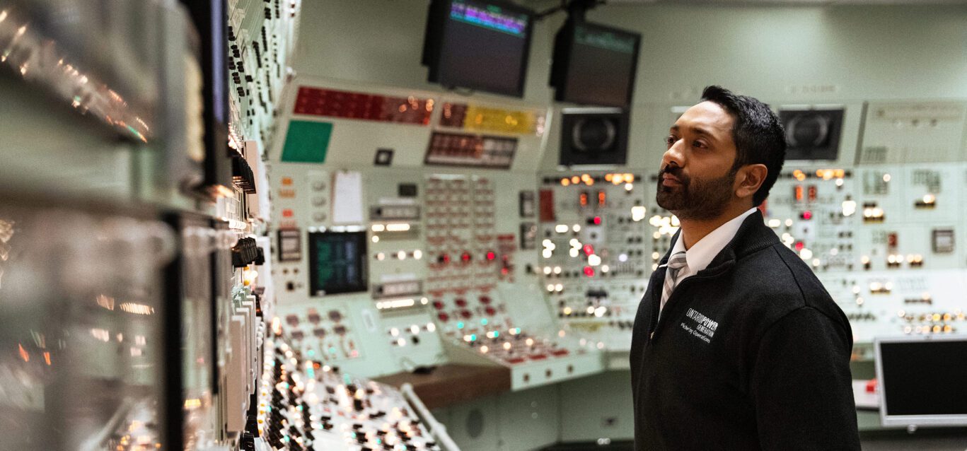 An authorized nuclear operator examines control room panels at the Pickering Nuclear Generating Station.