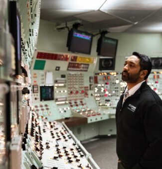 An authorized nuclear operator examines control room panels at the Pickering Nuclear Generating Station.