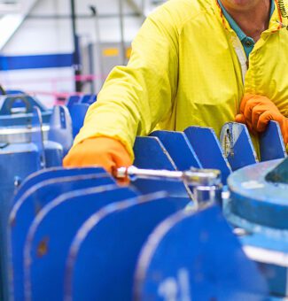 A worker in protective clothing works on nuclear isotope harvesting.