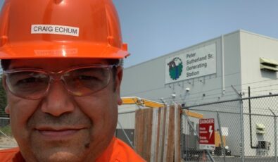 Craig Echum, a Mechanical Technician in OPG’s Abitibi Production group in the northeast, poses in front of OPG's Peter Sutherland Sr. Generating Station.