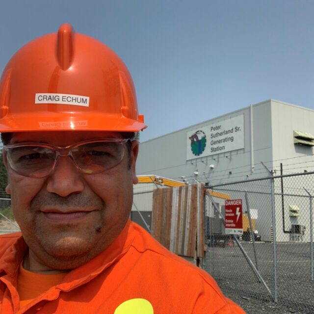 Craig Echum, a Mechanical Technician in OPG’s Abitibi Production group in the northeast, poses in front of OPG's Peter Sutherland Sr. Generating Station.
