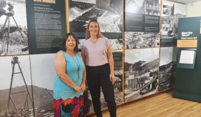 Judy Toupin, Curator of the Mattawa Museum, left, with Emily Salvalaggio, Senior Manager of OPG's Otto Holden and Des Joachims Generating Stations. Behind them is the museum's new exhibit on the Otto Holden Generating Station.