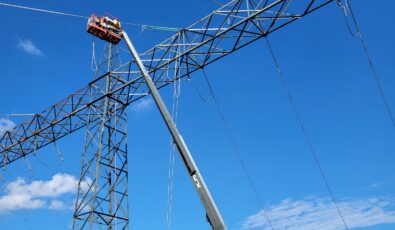 Workers use a boom lift to access a transmission tower over OPG's Sir Adam Beck II GS.
