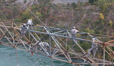 Workers use safety harnesses as they paint a gantry tower over Sir Adam Beck II GS.